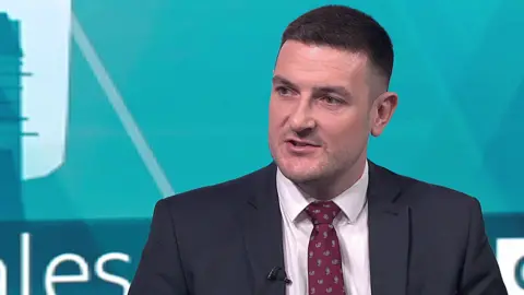 James Evans, wearing a suit and tie, is seated in a TV studio on Sunday's BBC Politics Wales programme