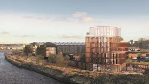 4D Studio Architects A CGI of how Crown Works Studios could look once built. A large glass building stands overlooking the River Wear. Next to it are large warehouse-like structures. The nearest one has Studio 7 painted across one of its outer walls.