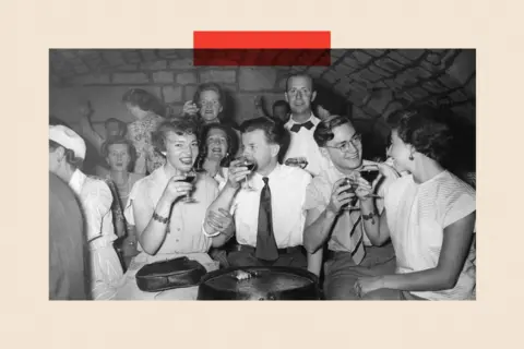 Getty Images A black and white photo of people in a bar drinking