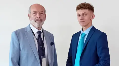 Reform UK Two men in jackets and ties. The one on the right wears a turquoise tie