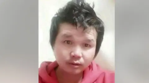 Hostages and Missing Families Forum Photograph of Suthisak Rintalak. His hair is styled pointing up and he is wearing a red hoodie