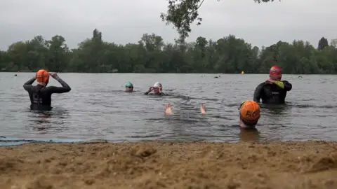 Elena Giuliano/PA Wire Protesters gathered for a swim at Ferris Meadow Lake in Surrey