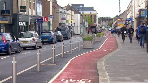 Cycle path in Keynsham showing red surface and different road markings