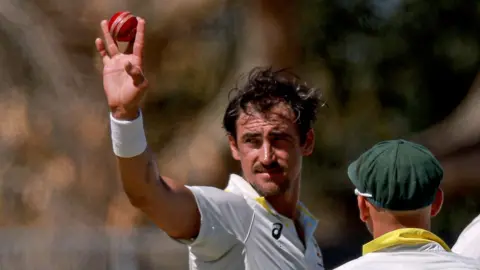 Mitchell Starc holds the ball aloft after taking five wickets