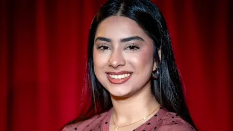 Noor Jahangir smiling with red background