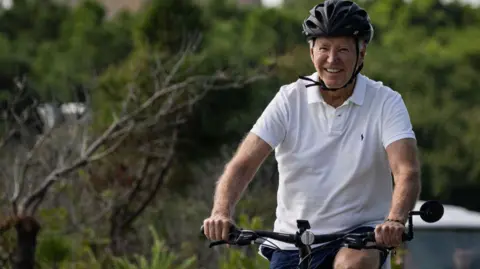 AFP O presidente dos EUA, Joe Biden, anda de bicicleta pelo Gordons Pond State Park em Rehoboth Beach, Delaware, no domingo