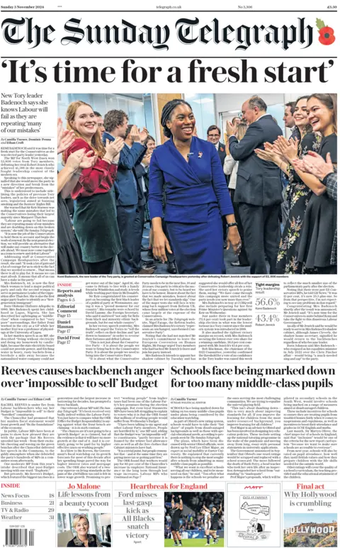 The front page of The Sunday Telegraph. The page features a smiling picture of Kemi Badenoch, who is being applauded by a group of people stood around her. The headline reads: 'It's time for a fresh start'.