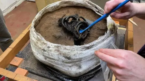 Bronze Age bracelets and neck rings being examined in a laboratory