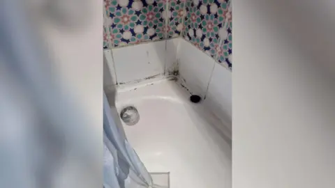 Lorraine Molloy A bath with dark marks in the corner. 