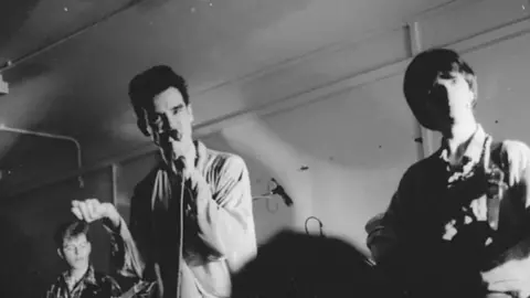 Colin Howe Black and white of the Smiths performing at the Salford Lads Club in 1983