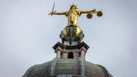 Scales of justice statue on top of the Old Bailey court in London