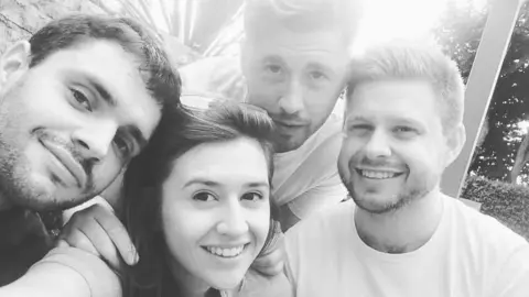 Natasha Bashford A black and white image as of the four adult siblings smiling together