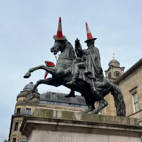The Duke of Wellington statue in Edinburgh with traffic cones on it.