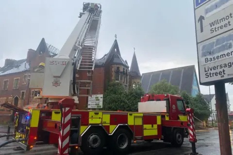 Derbyshire Fire and Rescue Service The firefighting operation in full flow at a former maternity hospital, with a fire engine and large ladder in use