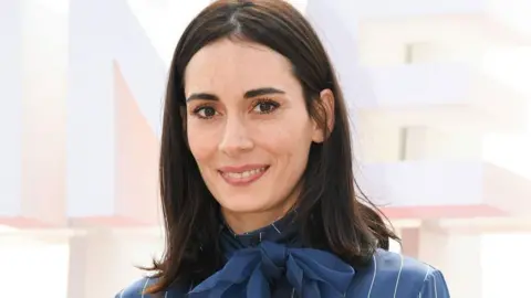 Alamy Melisa Sozen wears a blue blouse with a bow at a photocall during the Canne film festival in 2018