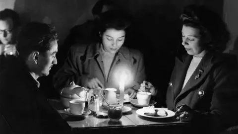 Getty Images Tea by candlelight in a City of London cafe when the governments 'No Power' order was observed between the hours of 9am - noon, and 2pm - 4pm, 10th February 1947. 