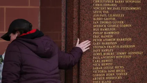 Reuters A Liverpool fan touches the Hillsborough Memorial at Anfield stadium which lists the names of those who died