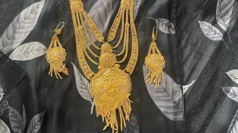 Metropolitan Police A multi-layered gold necklace and a matching set of gold earrings. 
