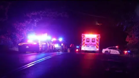 AP Image of flashing lights from police cars and an ambulances at Arcadia Lake.