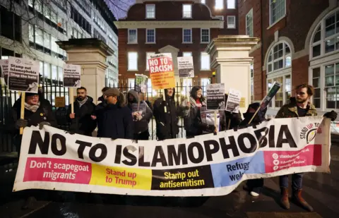 EPA Anti-Islamophobia demonstrators protest outside red brick building with the sign 'no to Islamophobia'