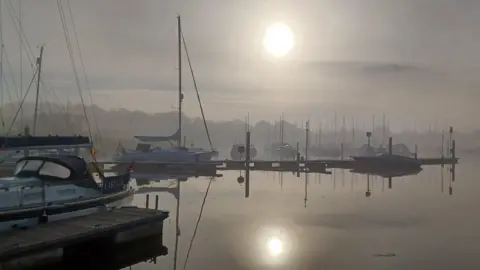 Jo Ware MONDAY - Misty sunlight over Lymington Quay, showing several boats and yachts