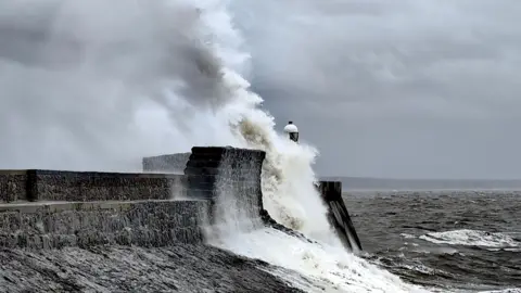 BBC Weather Watchers / Nadezna A wave crashes into a break wall in Wales