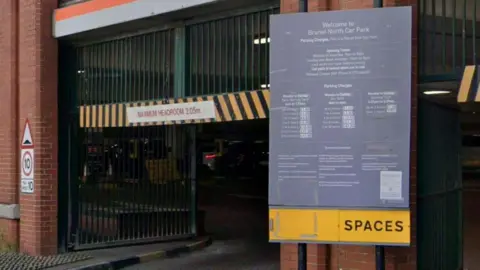 LDRS The entrance of the Brunel North car park in Swindon with a large sign displaying parking charges, a 10 mph road sign and a maximum headroom grid above it.