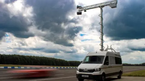 National Highways An illustration of a car driving past a van with the cameras attached to a large pole above it