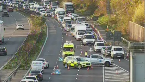 A congested motorway with police vehicles at the scene. 