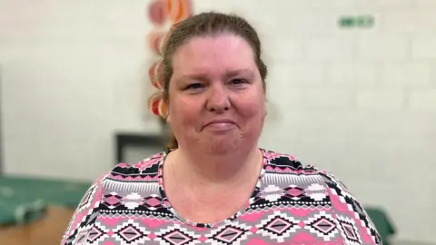 Tracy wearing a pink patterned top