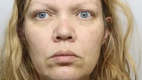 Police photograph of Fiona Beal. She is looking at the camera and has wavy fair hair and blue eyes.