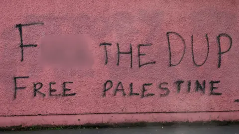 Pacemaker Graffiti on red wall, reas "F the DUP, Free Palestine!