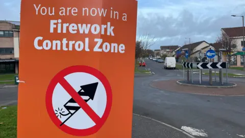 An orange sign with white writing on it reading 