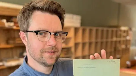 Rare Book Auctions Jim Spencer holding a piece of paper