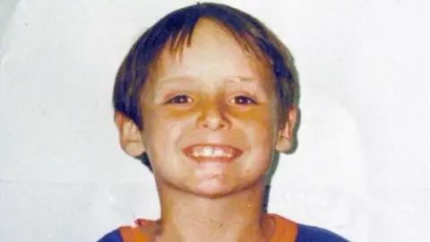 PA A smiling Wesley Neailey who has brown short hair and is wearing an orange and blue top.