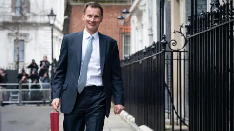 Getty Images Jeremy Hunt on Budget day with the red briefcase