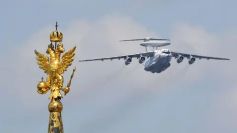 Getty Images A Beriev A-50 plane flies over a golden statue in Red Square during a military parade in 2020