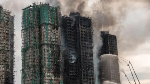 Getty Images Smoke rises from apartments after a major fire swept through several blocks at the Wang Fuk Court residential estate in Hong Kong's Tai Po district