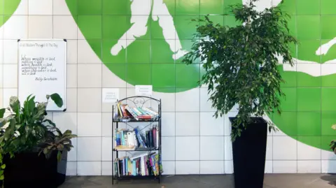 Alamy Oval Underground station interior features potted plants, book exchange, Thought of the Day