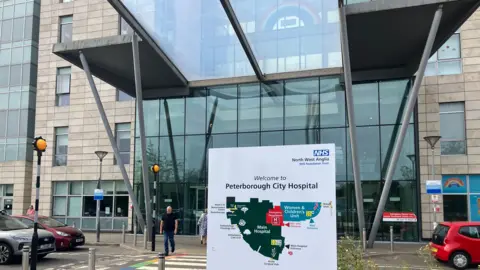 Shariqua Ahmed/BBC Peterborough City Hospital entrance with a white board, displaying a map of the hospital.