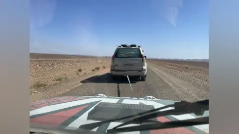 William Davies The Fiat Panda being towed by another car in the desert