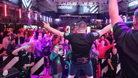 Slapfight UK Louis "The Razor" Robinson taken from the back with his arms aloft as fans celebrate and take pictures after he won the Slapfight British Heavyweight Championship match in Liverpool last year