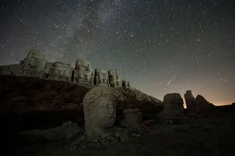 Kemal Aslan / AFP The Perseid meteor shower passes over the sculptures on Mount Nemrut in Adiyaman, southeast Turkey