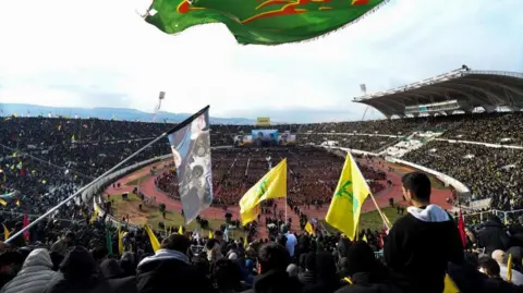 Crowds wave flags in a stadium