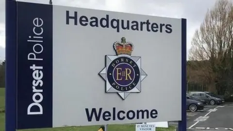 Blue and white sign saying: Dorset Police headquarters, welcome