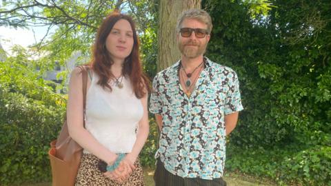 (L-R) Vix Weaver and James Kingston standing in by a tree