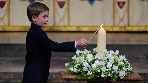 VE Day service honours last generation of WW2 veterans 10 Reuters A boy in a suit lights a cream-coloured candle in a wreath of white roses inside Westminster Abbey
