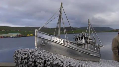 On top of the memorial to the Shetland Bus convoys is a model of one of the fishing boats used in the Shetland Bus operation.