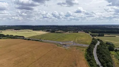 North Lincolnshire Council The photo is an aerial shot of a motorway. There is a roundabout in the middle, and fields either side. 