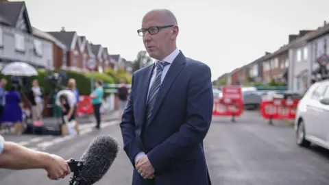 PA Media Patrick Hurley speaks to the media near the scene in Hart Street, Southport, where two children died and nine were injured in a